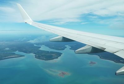 Cropped image of airplane wing over landscape