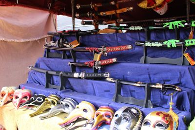 High angle view of masks and swords for sale at market