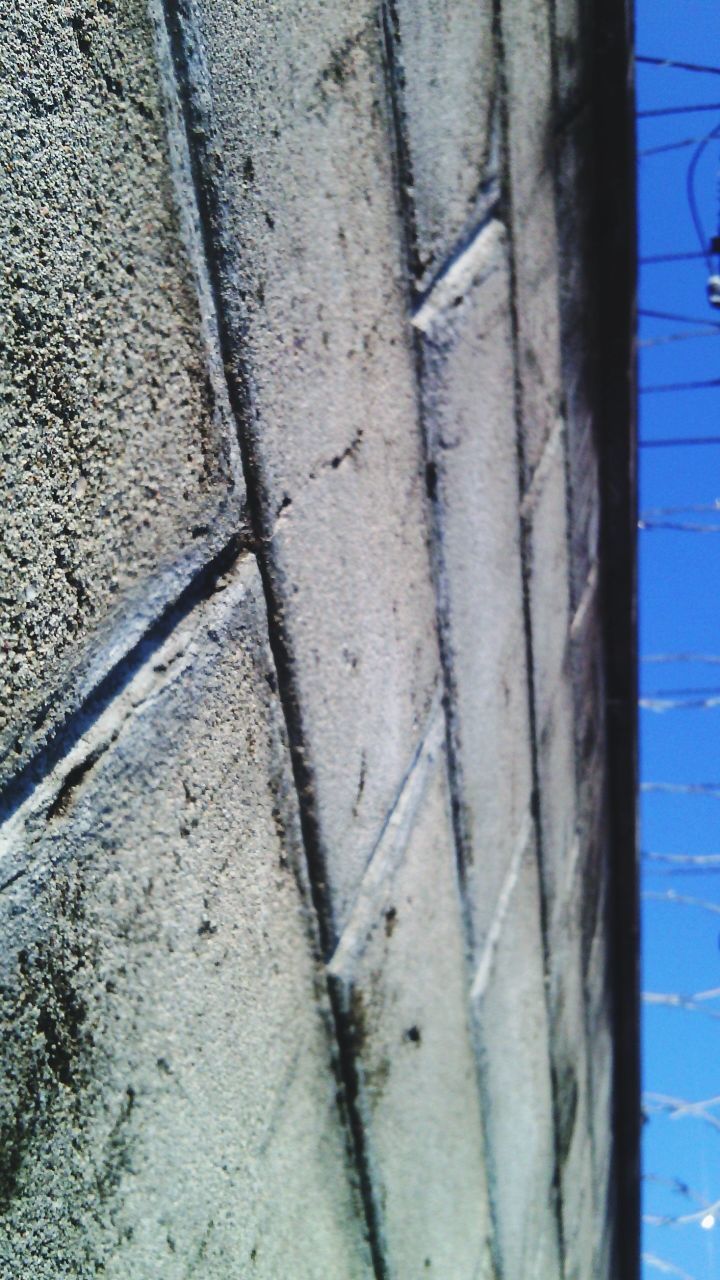 textured, wall - building feature, weathered, full frame, close-up, built structure, backgrounds, architecture, wall, damaged, old, pattern, rough, outdoors, day, low angle view, no people, deterioration, rusty, detail