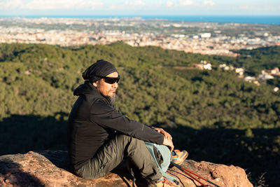 Portrait of young man sitting on rock