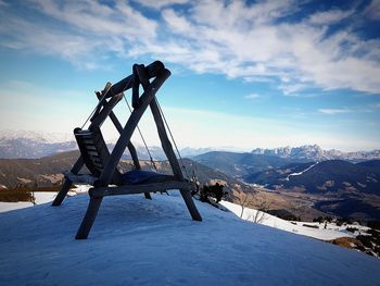 Ski lift on snowcapped mountains against sky