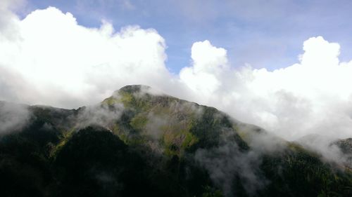 Scenic view of mountains against cloudy sky