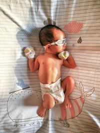 High angle view of baby boy lying on bed