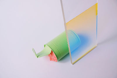 High angle view of multi colored paper against white background