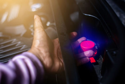 Cropped hand of man holding illuminated lighting equipment