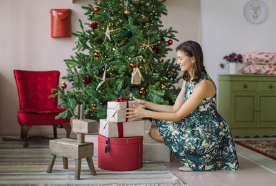 Full length of woman holding red table at home