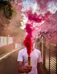 A man playing with red smoke bomb