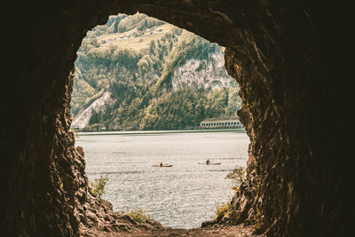 Scenic view of sea and mountain seen through cave