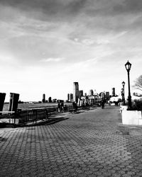 Street by buildings against sky in city