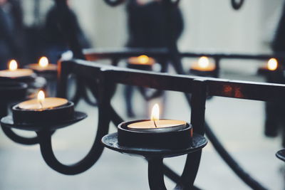 Close-up of lit candles in candlestick holder