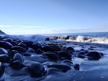 Rocks on beach against sky