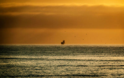 Scenic view of sea against orange sky