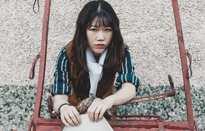 Portrait of young woman sitting outdoors