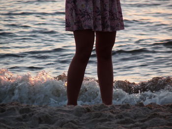 Low section of woman standing on beach