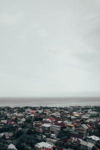 High angle view of townscape by sea against sky