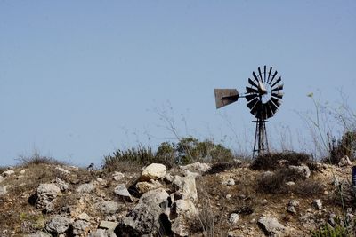 Traditional windmill on field against clear sky