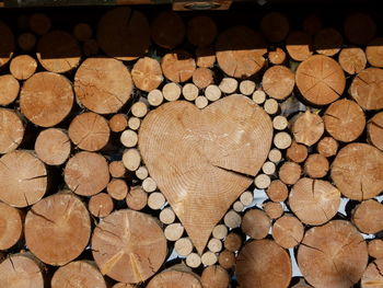 Close-up of heart shape wood amidst logs