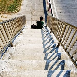 Rear view of man walking on staircase