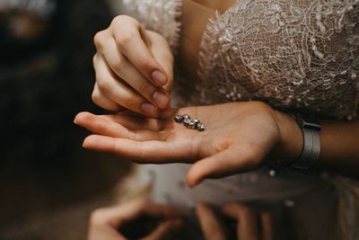 Midsection bride holding jewelry