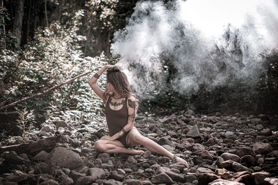 Woman with arms raised in forest
