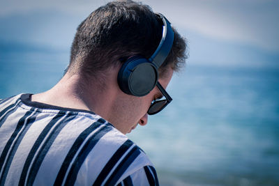 Relaxed man on the beach listening to music with his headphones