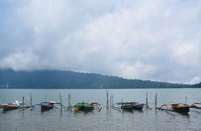 Boats moored in sea against sky