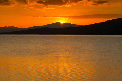 Scenic view of silhouette mountains against romantic sky at sunset