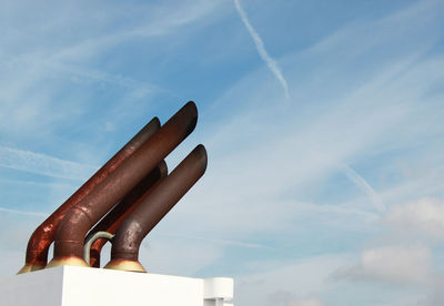 Low angle view of smoke stacks against sky