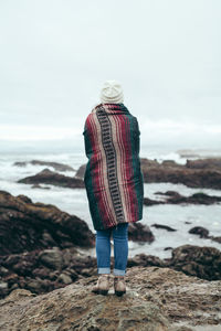 Full length woman standing at beach against sky