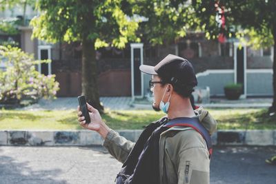 Side view of man photographing with mobile phone