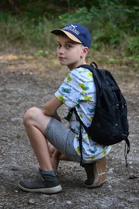 Portrait of young boy sitting on field