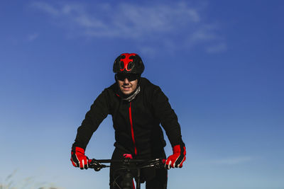 Man with umbrella against blue sky