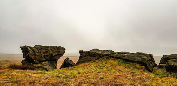 Rock formations on landscape against sky