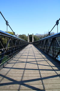 Footbridge against clear blue sky