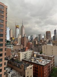 Modern buildings in city against cloudy sky