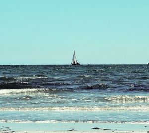 Sailboat sailing on sea against clear sky