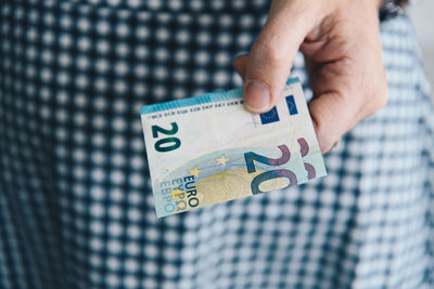 Midsection of woman holding paper currencies