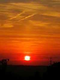 Scenic view of silhouette landscape against orange sky