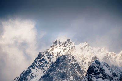 Low angle view of snowcapped mountains against sky