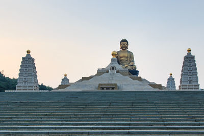 Low angle view of buddha statue at fo guang shan against clear sky
