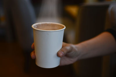 Midsection of woman holding coffee cup