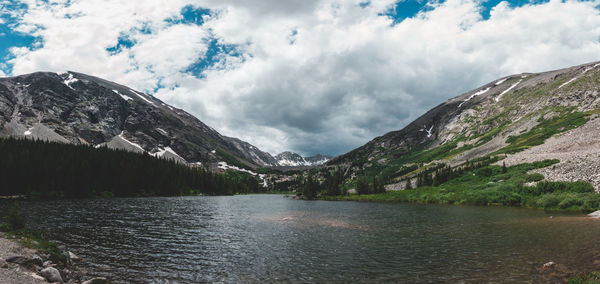 Scenic view of river and mountains against cloudy sky