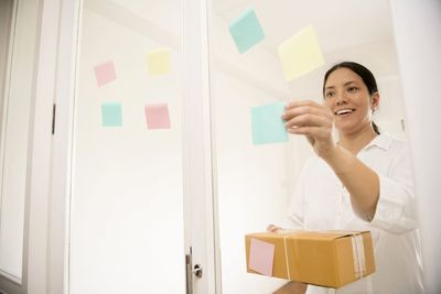 Smiling young woman standing against wall