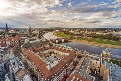 High angle view of buildings by river in city against sky