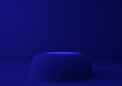 Close-up of light bulb on table against blue background