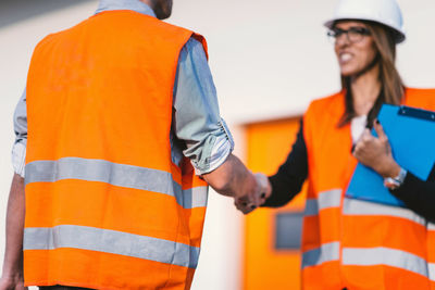 Low angle view of engineers shaking hands at construction site