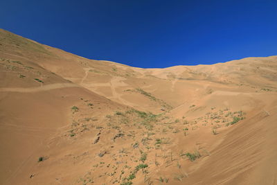 Scenic view of desert against clear blue sky