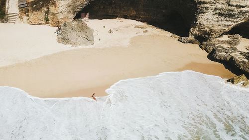 Aerial view of woman sitting on beach