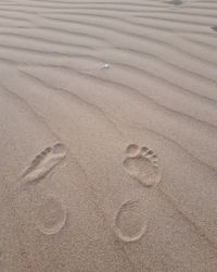 High angle view of footprints on sand at beach