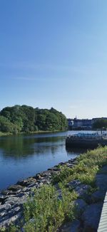 Scenic view of river against clear blue sky